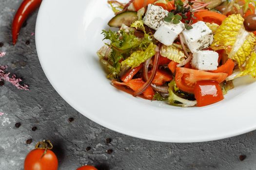 Greek salad with fresh vegetables, feta cheese and black olives.