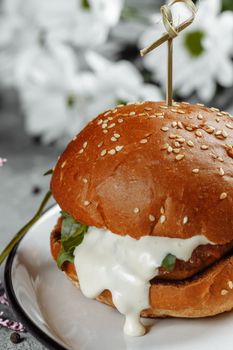 burger with fries and sauce on a white plate.