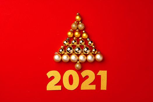 Christmas tree made of gold baubles on red background top view
