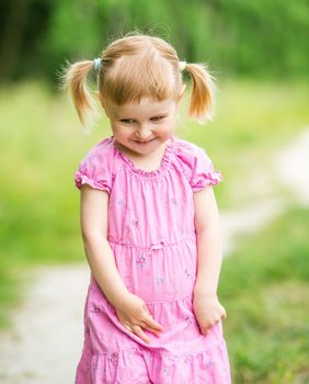 Cute little girl on the meadow in summer day