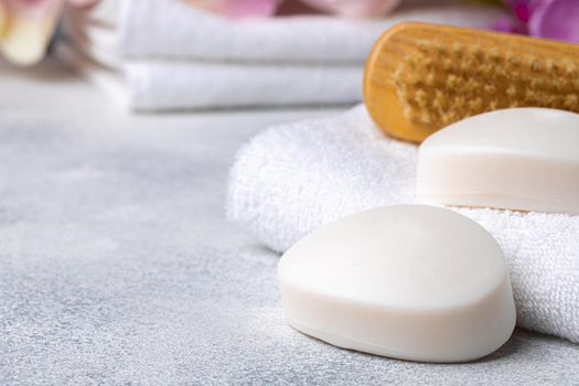 Bar of natural handmade soap, towel and spa objects, close up