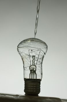 Light bulb made of water splashes. black and white dark photo