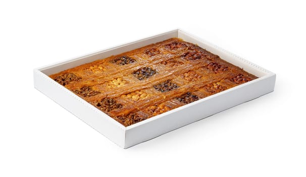 Assortment of Turkish baklava dessert in a white box isolated on white background