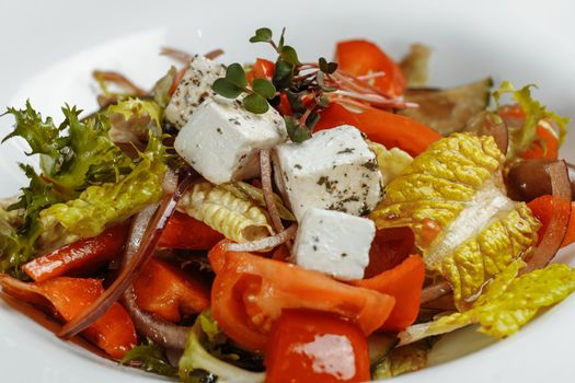 Greek salad with fresh vegetables, feta cheese and black olives.