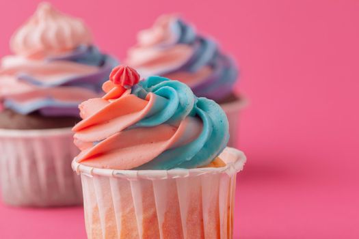 Tasty cupcakes sweets on pink background close up