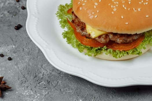 hamburger with fries and salad on the plate.