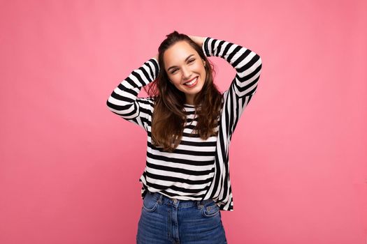 Portrait of positive cheerful fashionable woman in casual clothes isolated on pink background with copy space.