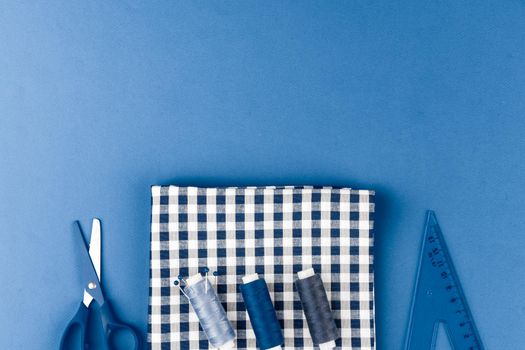 Tayloring accessories on classic blue background, top view. Close up.