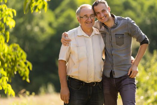 Father and his son looking at the camera in the garden