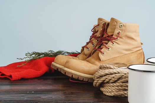 Mountain boots and hiking gear on wooden planks close up