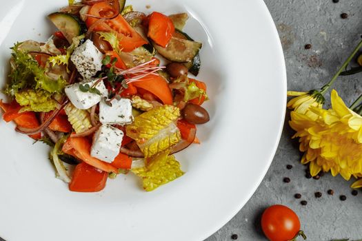 Greek salad with fresh vegetables, feta cheese and black olives.