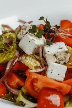 Greek salad with fresh vegetables, feta cheese and black olives.