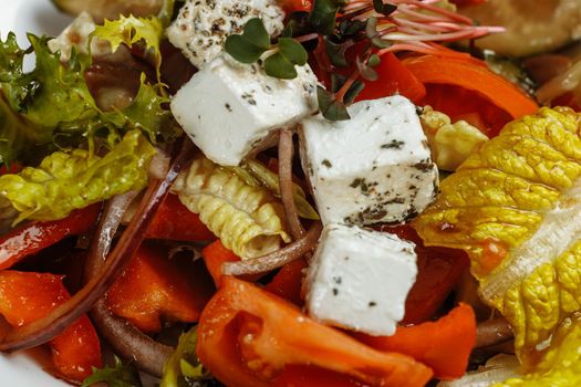 Greek salad with fresh vegetables, feta cheese and black olives.