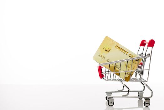 Shopping cart with credit card and copy space on white background - image