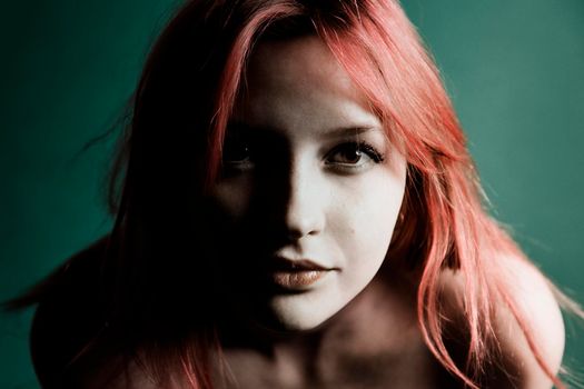 Pretty Young redhead girl on a green background