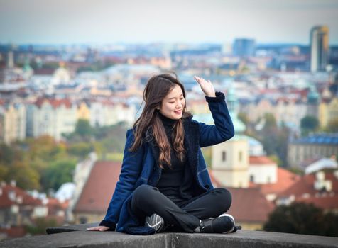 Prague, Czech Republic - October 10, 2017: Pretty girl poses and looks at the old city of Prague from observation decks near Prague Castle, Prague Czech Republic