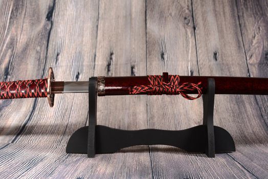 Katana sward in the stand on the wooden background