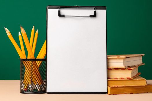 Blank clipboard with copy space and school supplies front view