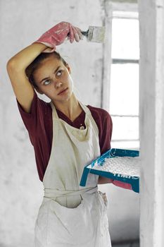 woman painter In white apron home renovation interior. High quality photo