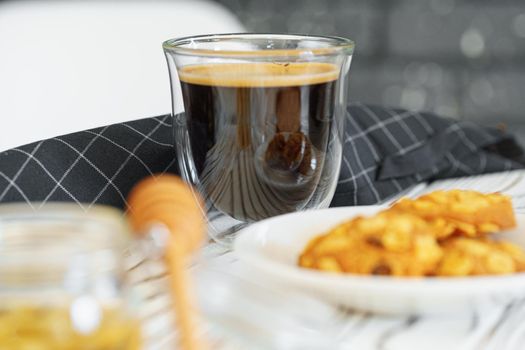 Glass cup of coffee on white wooden kitchen table