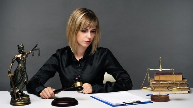 A young fair woman judge works in her office. - image