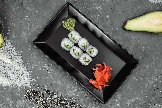 Delicious, juicy and mouth-watering maki with cucumber. Sushi on a gray background.