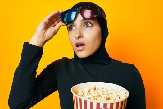 pretty woman in black hijab popcorn 3D glasses cinema studio lifestyle. High quality photo