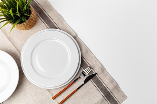 Fork, knife and plate on towel. Isolated on white background. Close up.