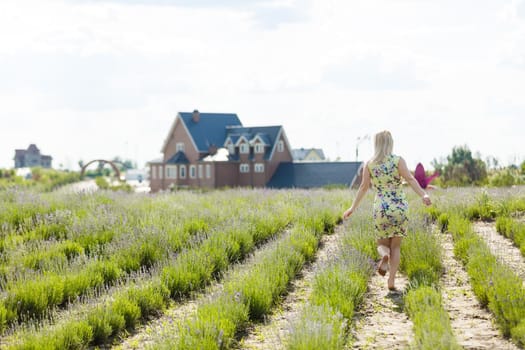 Woman standing with open arms on a lavender field