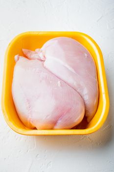 Fresh chicken breast meat in open tray, on white background