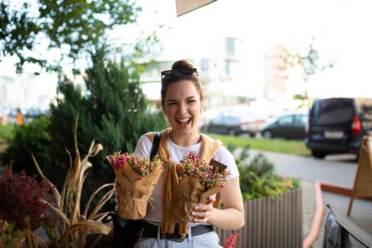 attractive young woman in casual look buys flowers in the store.