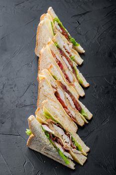 Sandwich bread tomato lettuce and yellow cheese, on black background