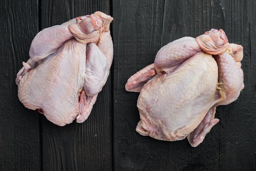 Fresh raw whole chicken carcass, on black wooden table, top view