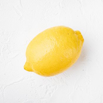 Yellow ripe lemon set, on white stone table background, with copy space for text