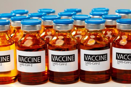 Sars-cov-2 vaccine vial bottles on white table close up
