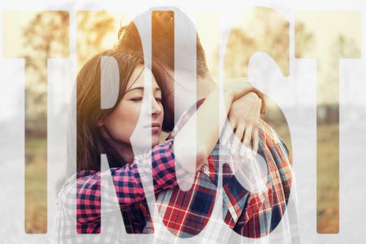 Double exposure word trust combined with image of loving couple embracing at sunset outdoor