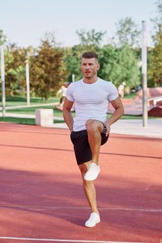 athletic men doing exercises on the sports ground in summer. High quality photo