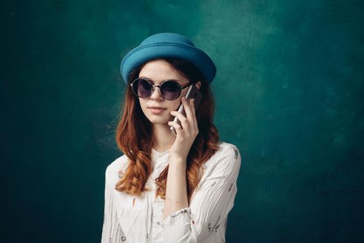 fashionable woman in blue hat with phone in hands communication technology. High quality photo