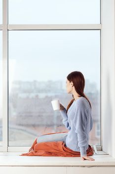 woman near the window dreamy look rest at home comfort. High quality photo