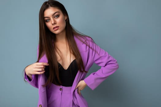 Young brunette woman sexy nice-looking attractive charming elegant fashionable serious isolated over blue color background with empty space for text.