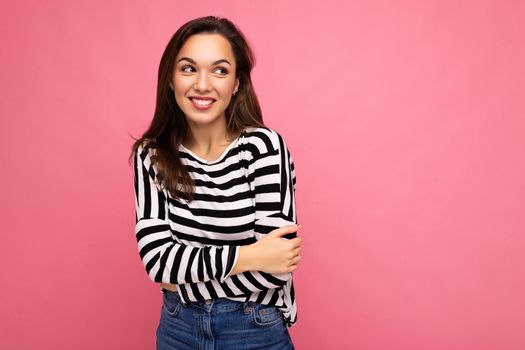 Portrait of positive cheerful fashionable woman in casual clothes isolated on pink background with copy space.
