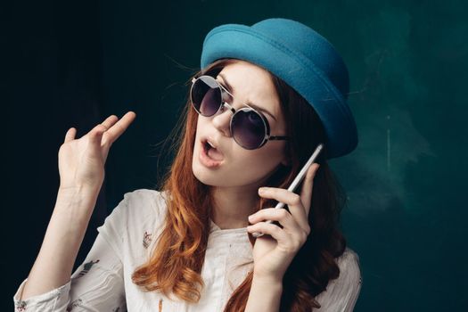 fashionable woman in blue hat with phone in hands communication technology. High quality photo