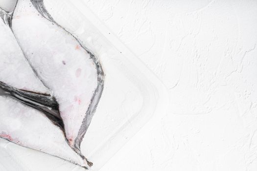 Halibut iced fillet plastic pack set, on white stone table background, top view flat lay, with copy space for text