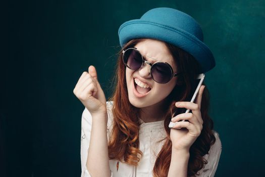 fashionable woman in blue hat with phone in hands communication technology. High quality photo