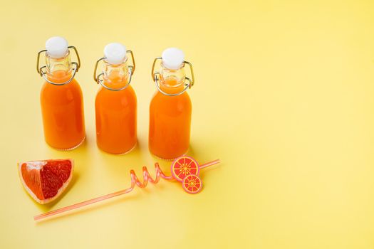 Grapefruit juice set, on yellow textured summer background, with copy space for text