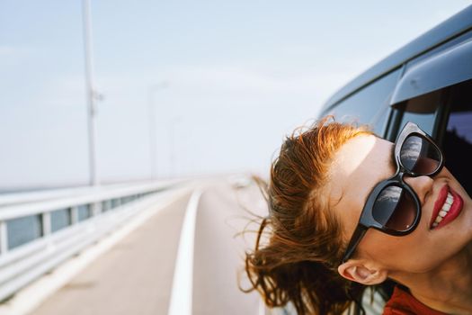 woman looking out of car window wearing sunglasses travel lifestyle. High quality photo