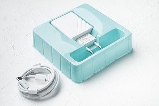 Adapter and USB Cable new package set, on white stone table background