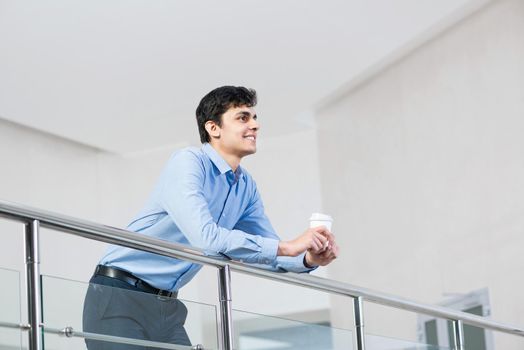 man businessman stands on the balcony with coffee