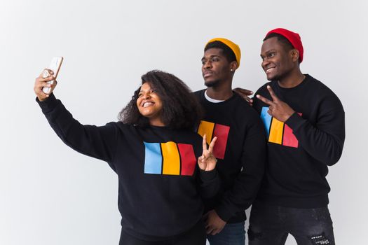 Friendship and fun concept - Group of friends afro american men and woman taking selfie in studio on white background