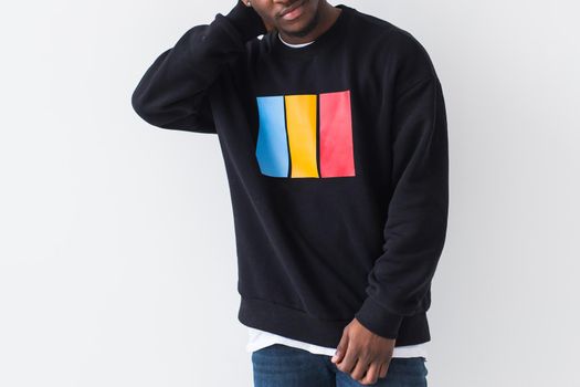 Studio shot of young handsome African man wearing hoodie against white background.